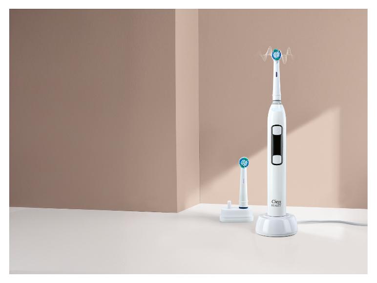 Ensemble brosse à dents électrique blanche avec chargeur et tête de rechange.