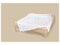 Couette blanche à motif ondulé sur un lit en bois avec des draps beiges