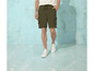Un homme portant un short cargo vert et des baskets blanches.