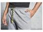 Un homme portant un pantalon de survêtement gris avec des cordons jaunes.