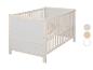 Lit bébé en bois clair avec panneaux blancs et barreaux latéraux.