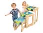 Deux enfants jouent avec une table à eau en bois avec des bacs bleus et un robinet.