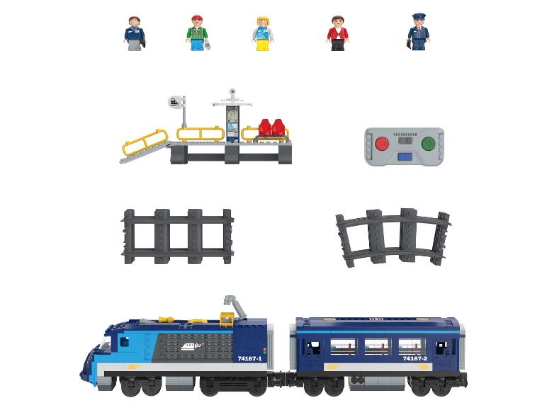 Un train bleu avec une locomotive et un wagon, des rails, une gare et des figurines