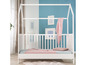 Un lit d'enfant en bois blanc en forme de maison.