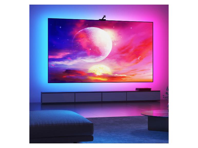 Grande télévision avec rétroéclairage ambiant affichant une scène spatiale vibrante dans un salon moderne.