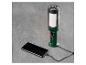 Une lampe de travail verte avec trois lampes, qui charge un smartphone.