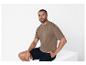 Un homme portant un t-shirt marron et un short noir.