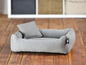 Un panier pour chien gris avec un coussin.