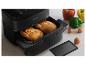 Friteuse à air Philips noire avec deux poulets entiers et légumes.