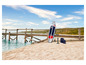 Un paddleboard gonflable, une pompe et un sac sur une plage de sable