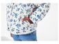 Blouson matelassé à fleurs bleu marine sur fond blanc et jeans.