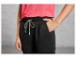 Pantalon de jogging noir avec des lacets verts et un t-shirt rose.