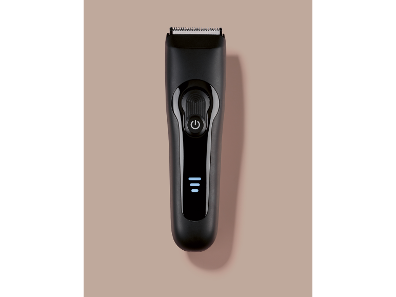 Tondeuse à cheveux noire avec bouton d'alimentation et indicateur de charge.