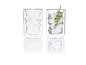 Deux verres au design torsadé, l'un rempli d'eau, de glace et de concombre.