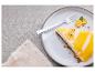 Part de cheesecake au citron avec glaçage, noix et kumquats sur une assiette