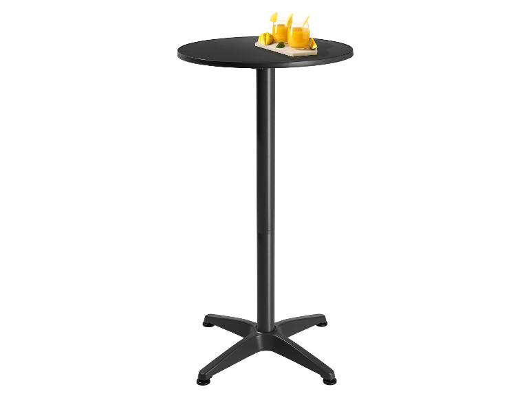 Table de bar noire avec deux verres de jus d'orange et des fruits sur un plateau