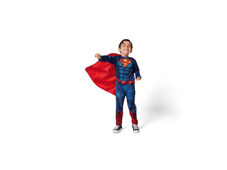 Enfant en costume de Superman, avec une cape rouge, souriant à la caméra