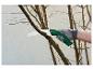 Scier une branche d'arbre avec une scie à main.