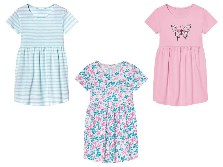 Trois robes pour filles : rayée, rose avec un papillon et à fleurs.