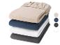Pile de quatre draps-housses unis en beige, bleu, blanc et gris foncé.