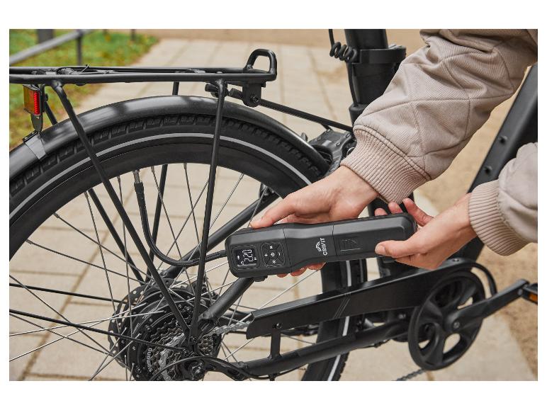 Personne gonflant un pneu de vélo avec une pompe à air portable Crivit.