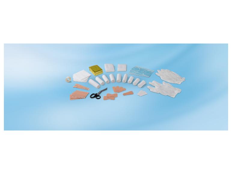 Trousse de premiers secours avec bandages, pansements, gants, masques et ciseaux sur fond bleu.