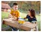 Enfants jouant avec des instruments de musique jouets sur une table de pique-nique en bois.