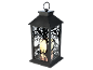 Lanterne décorative noire avec silhouettes de corbeaux et d'arbres, éclairée par une bougie.