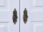 Deux portes blanches avec des poignées en laiton antique.