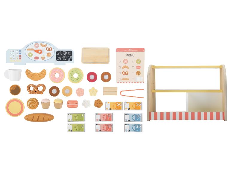 Un ensemble de jouets de boulangerie avec une caisse enregistreuse, des aliments, un menu et de l'argent.