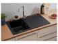 Évier de cuisine noir avec robinet, plan de travail en bois et carrelage blanc.