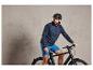 Homme avec un casque sur un vélo noir.