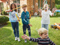 Des enfants jouent avec des bulles de savon et un camion jouet dans le jardin.