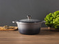 Une casserole en fonte grise avec couvercle de Le Creuset sur une table en bois
