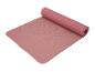 Un tapis de yoga rose avec une texture, roulé.