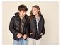 Deux enfants souriants portant des doudounes noires et des vêtements décontractés.