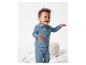 Bébé souriant portant un ensemble pantalon et chemise en tissu bleu clair.