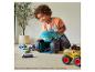 Un enfant joue au sol avec un coffret de jeu Hot Wheels Monster Trucks.