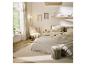 Chambre à coucher lumineuse avec un lit beige, un tapis clair et une chaise d'appoint.