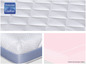 Un matelas blanc avec une bordure bleue et un coussin rose.