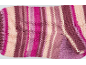 Tissu tricoté rayé dans des tons de rose, violet et crème.