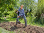 Un homme creuse avec une pelle dans le jardin.