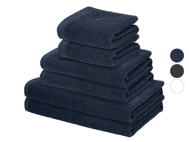 Pile de serviettes bleu foncé avec échantillons de couleurs pour le bleu foncé, le gris et le blanc.