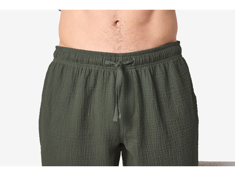 Gros plan du torse d'un homme portant un short en coton froissé vert foncé