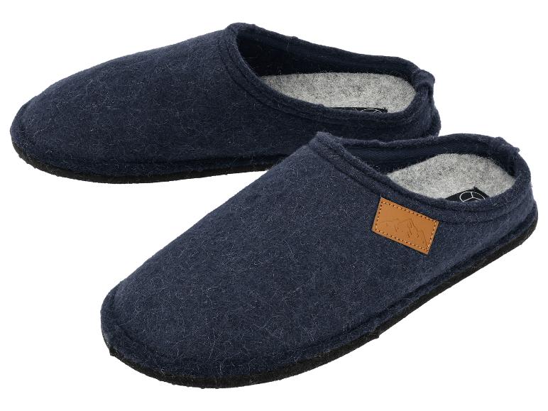 Une paire de chaussons en feutre bleu foncé avec un détail en cuir marron clair.