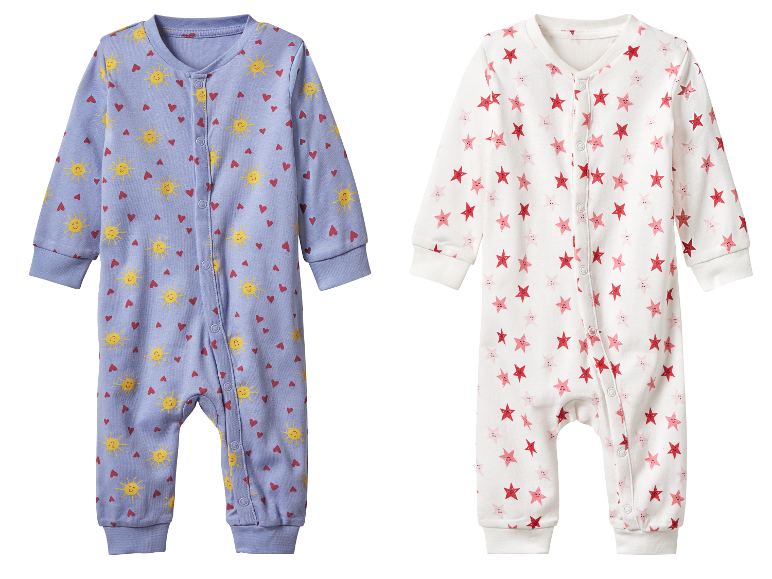 Deux pyjamas bébé, l'un à motifs soleils et cœurs, l'autre à motifs étoiles.