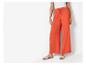 Pantalon large orange et sandales plates : look décontracté estival.