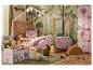 Chambre d'enfant avec lit en bois, armoires roses et décor sur le thème de la forêt.