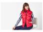 Une femme porte une veste en duvet rouge et un pull à rayures.