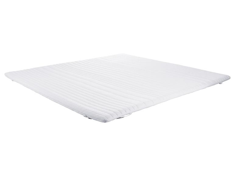 Protège-matelas blanc et doux avec des lignes verticales.